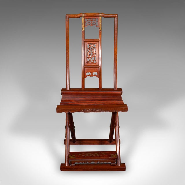 This is a striking vintage folding veranda chair. An Oriental, teak campaign seat with distinctive brass embellishment,...