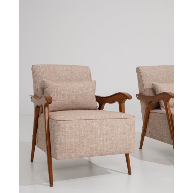 Rendered in the refined idiom of Mid-Century Modernism, this distinguished pair of French armchairs embodies the era's...