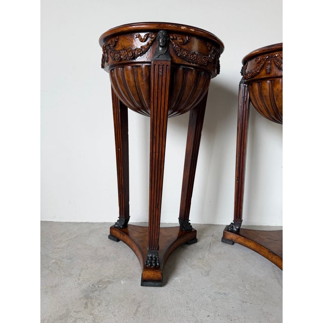 Elegant pair of Theodore Alexander Neoclassical style mahogany plant stands featuring beautifully carved floral garlands,...