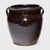 This antique Chinese jar from the early 20th century is cloaked inside and out with a dark brown glaze, shimmering with...
