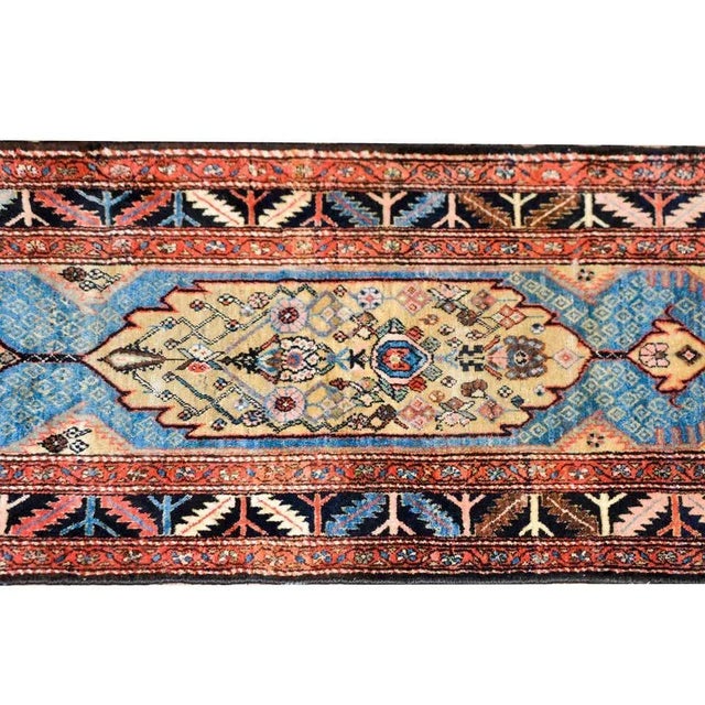 A stunning early 20th century Persian Malayer runner with multiple central medallions with stylized flowers amidst a field...