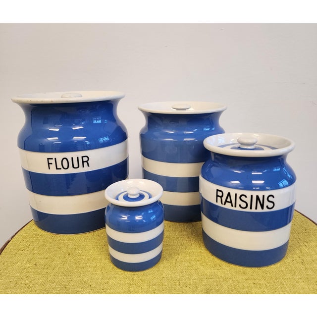 An assembled collection of four blue and white banded striped Cornish Ware kitchen storage jars. The blue and white stripe...