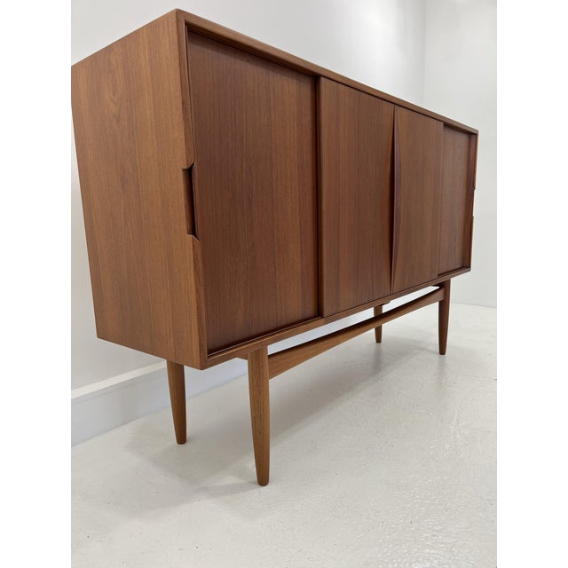 Super elegant 60s sideboard / highboard. High quality workmanship, veneered in teak. with 4 sliding doors. Inner life...