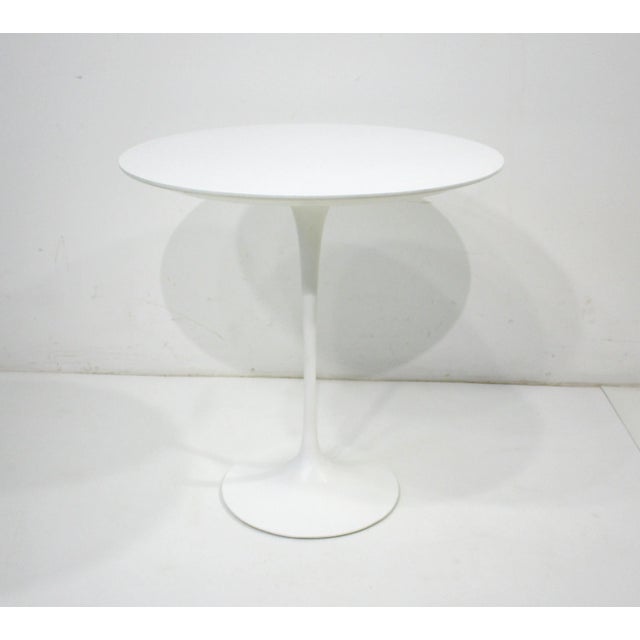 A satin white tulip side table with cast steel base and a round Laminate top designed by the mid century iconic designer...