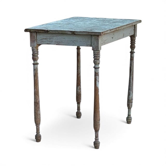 A charming French farmhouse side table with beautifully aged paint, delicate turned legs, and a single drawer for storage....