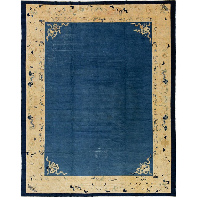 Beautiful antique Art Deco hand-knotted wool rug with a blue field. This Chinese rug has a tan frame in a gorgeous all-...