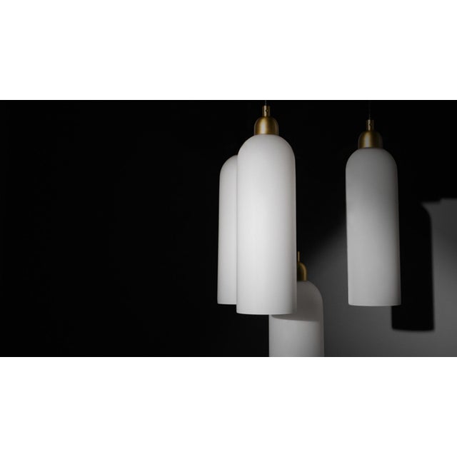 A gleaming constellation of nine opal glass arches strike the eye with their sleek arrangement and brass accents. This...