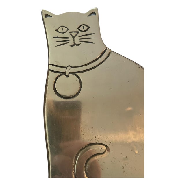 Solid brass trivet of a cat wearing a collar from midcentury brand Rubel and Co, footed on the underside so can be easily...