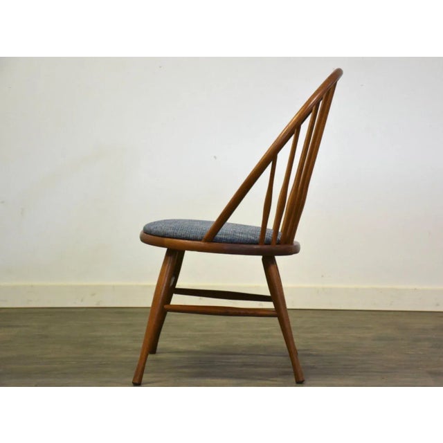 A mid century modern Windsor back teak color lounge chair with a newly reupholstered blue seat made by Heywood Wakefield....