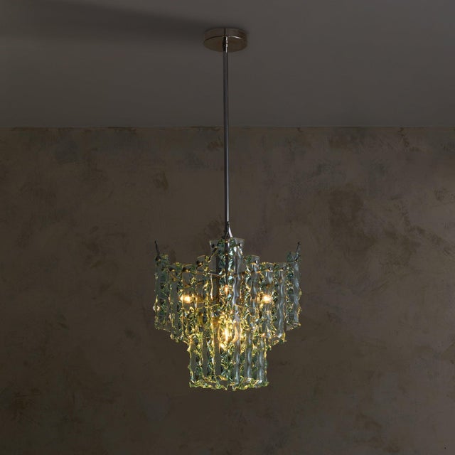 An Italian glass and chrome pendant crafted in the 1970s. The slender, irregular glass elements descend in layered tiers,...