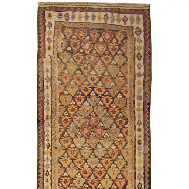 An early 20th century Persian Qazvin Kilim runner with intricately woven multicolored pattern surrounded by multiple...