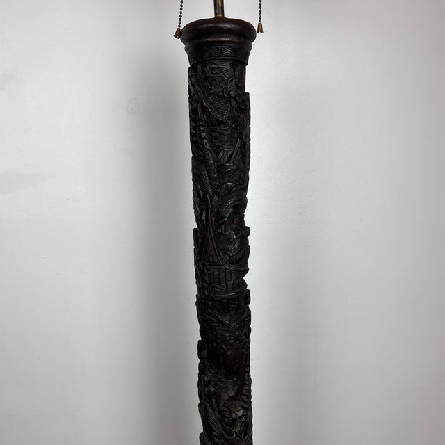 Truly amazing hand carved ebonized floor lamp. This Chinese export is heavily carved with village scenes of people,...