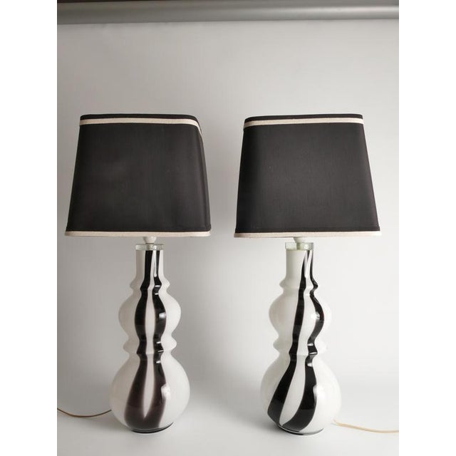 This striking pair of 1970s art glass table lamps showcases the bold sculptural aesthetic and refined craftsmanship...