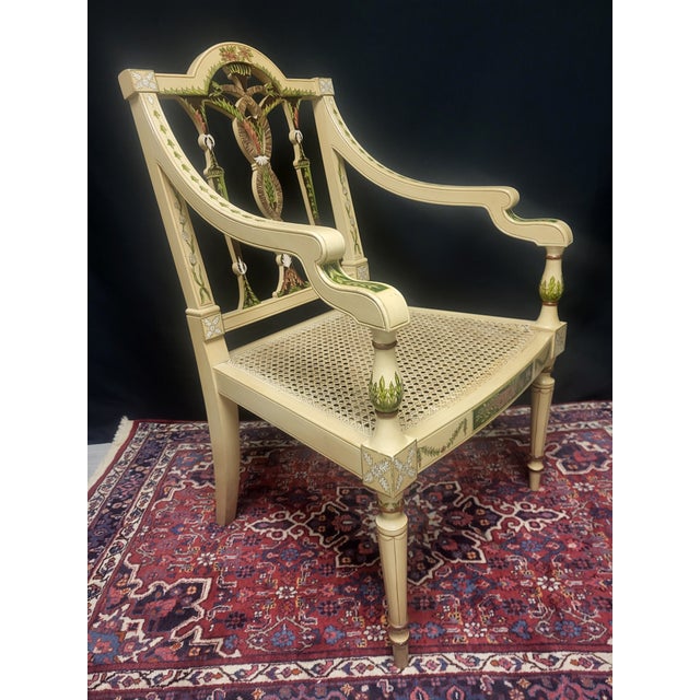 A striking pair of hand-painted hand french caned armchairs inspired by English Adam and Sheraton designs. Finished in...