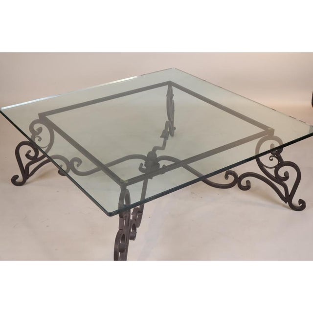 An elegant and substantial Baroque-style wrought iron and glass low table, dating to the 20th century. Featuring a large...