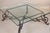 An elegant and substantial Baroque-style wrought iron and glass low table, dating to the 20th century. Featuring a large...