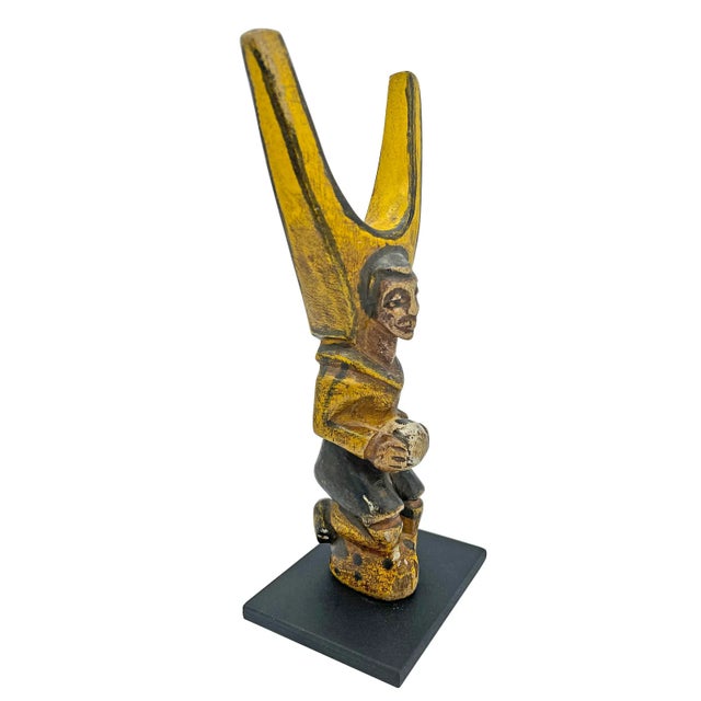 Fantastic carved West African slingshot depicting a soccer player in classic colonial influenced style. Kneeling figure...