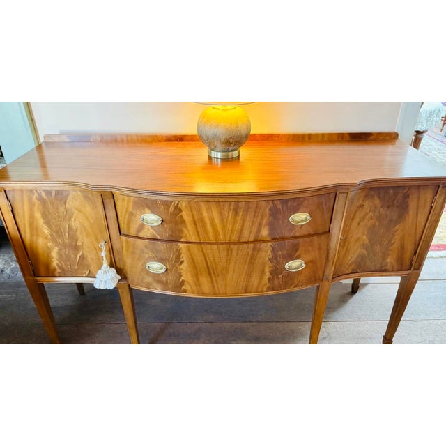 Elegant American sideboard or buffet dating to the late 1920s–1930s, executed in the Federal / Sheraton Revival style....