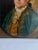 This refined oil on canvas portrait captures a distinguished gentleman in half-length, presented within an illusionistic...