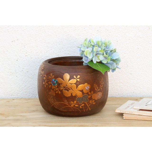 Look closely at the gold flowering branch worked across this bowl and one small detail stops you, a single petal isn't...