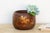 Look closely at the gold flowering branch worked across this bowl and one small detail stops you, a single petal isn't...