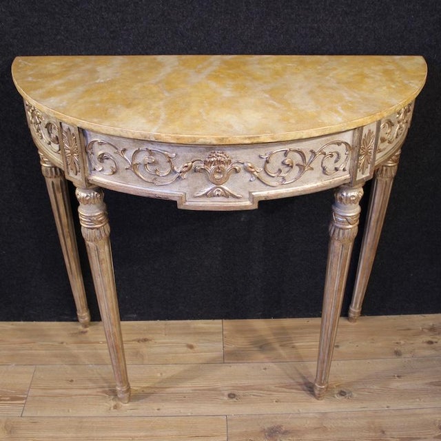Italian console table from the second half of the 20th century. A Louis XVI-style furniture of carved, lacquered, and...