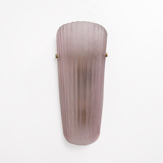 An elegant pair of italian wall lamps with handcrafted murano glass lampshades in a delicate blush pink. The elongated...