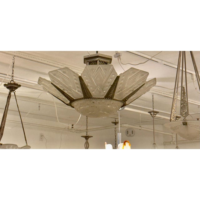 French Art Deco chandelier by famous French artist G Leleu. Nine matching geometric glass panels surround a large glass...