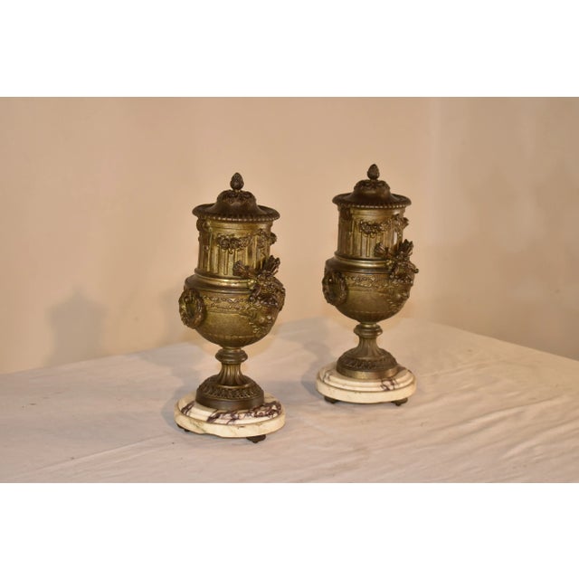 Pair of 19th century mantle urns from France. The pair are lidded, and are wonderfully cast with garlands, reeded design...
