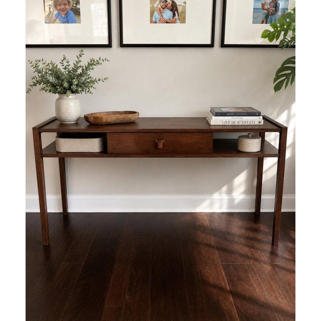 An elegant Edward Wormley for Dunbar walnut console table showcasing the clean, understated lines that made Wormley one of...