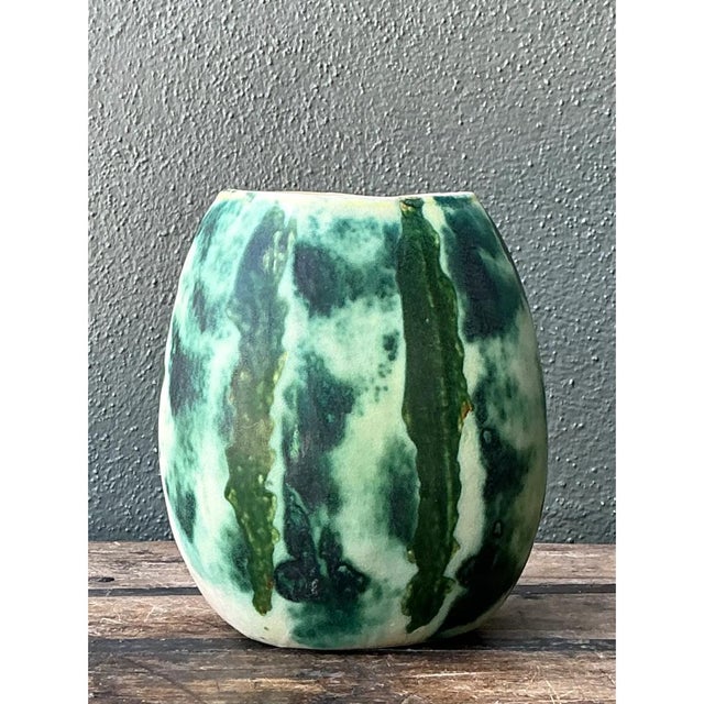 This exquisite mid-century ceramic vase commands attention with its vibrant, dynamic glaze and organic, gently rounded...