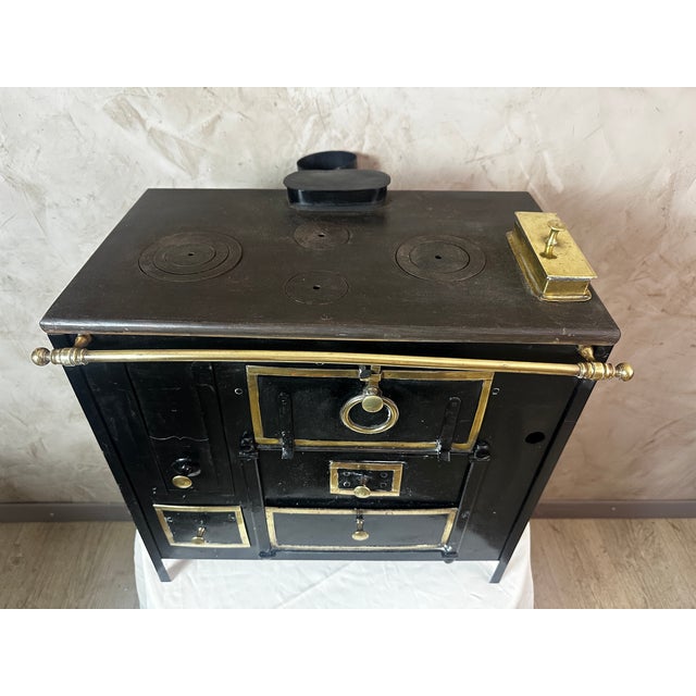 A charming antique cast iron children's stove dating from the 1900s, a true testament to toys of yesteryear. Crafted with...
