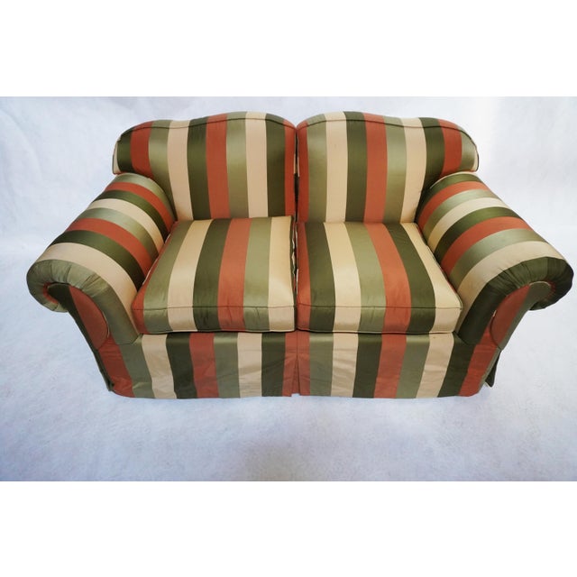 Edward Ferrell two-seater skirted loveseat, with large rolled arms. The upholstery is done in a beautiful, wide, multi-...