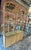 Beautiful vintage rattan and woven cane etagere cabinet featuring an elegant arched silhouette, glass shelving, and...