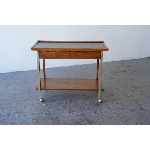 A Mid-century modern Bar Cart or Serving Cart by American of Martinsville, featuring a warm walnut-toned case, sculpted...