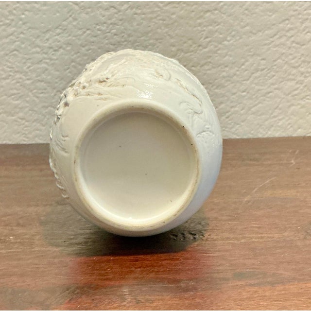 A refined and authentic Chinese Blanc de Chine porcelain vase, beautifully modeled with a tranquil naturalistic scene of...