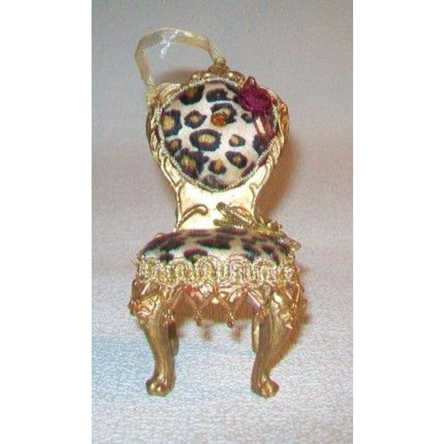 This Victorian style miniature gilded chair upholstered in red and leopard velvet ornament with a gold ribbon hanging loop...