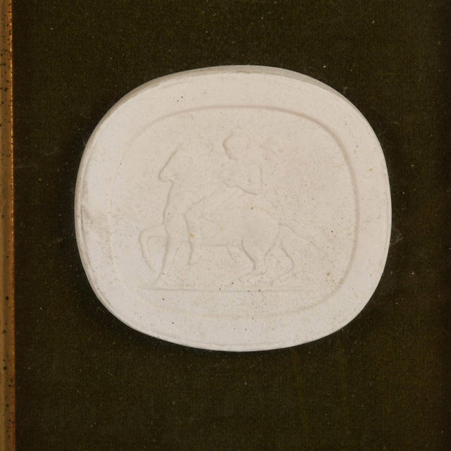 This Framed Pair of Military Medallions showcases a collection of intricately crafted white relief medallions arranged...