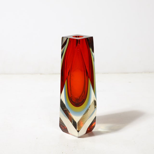 This Mid-Century Modernist hand-blown faceted Murano glass "Sommerso" vase, crafted in ruby red and transparent glass, is...