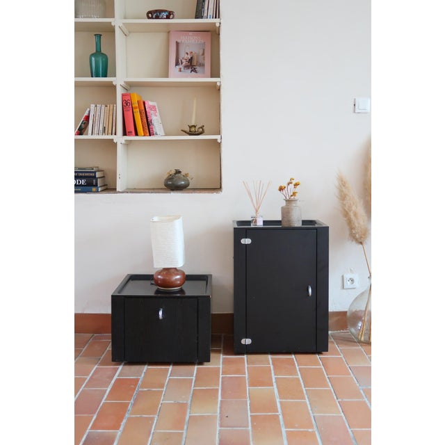 Pair of black lacquered cabinets by Roche Bobois, France, 1990s. One is a tall module with a hinged door, the other a low...