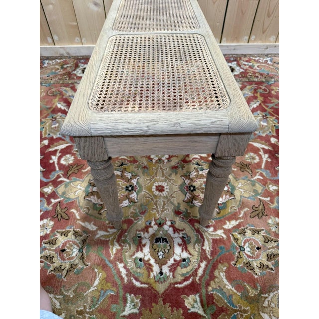 A Louis-Philippe style office bench in solid oak, with a seat divided into three panels of natural woven cane. The six...