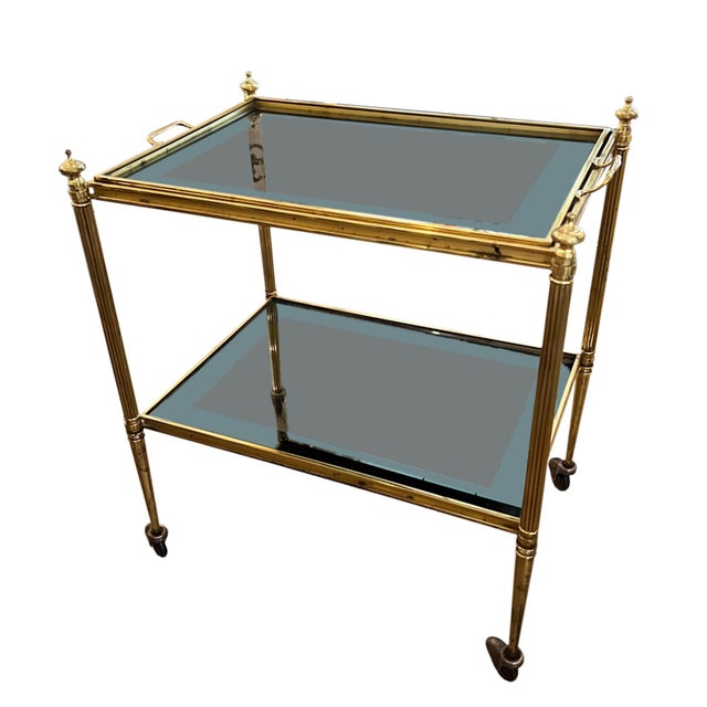 This decorative small drinks trolley was made in France in the 1960s. The lacquered brass frame is finished with...