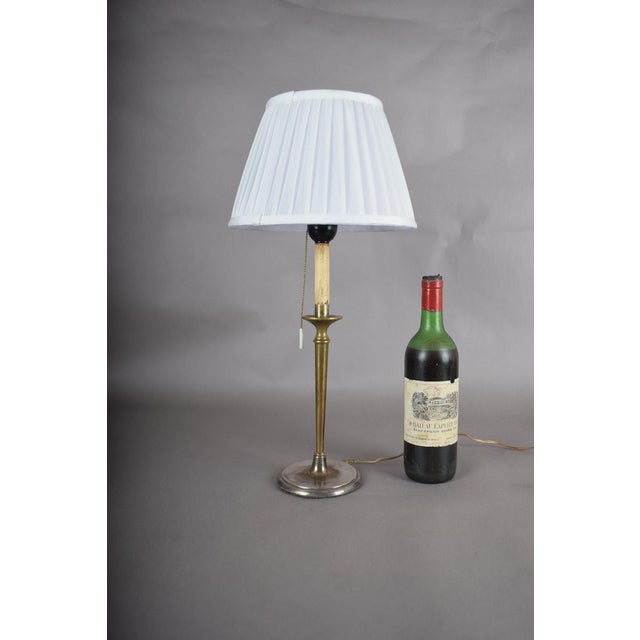 Silvering brass was a common finishing technique for candlestick-form lamps, prized for its cool, reflective shine layered...