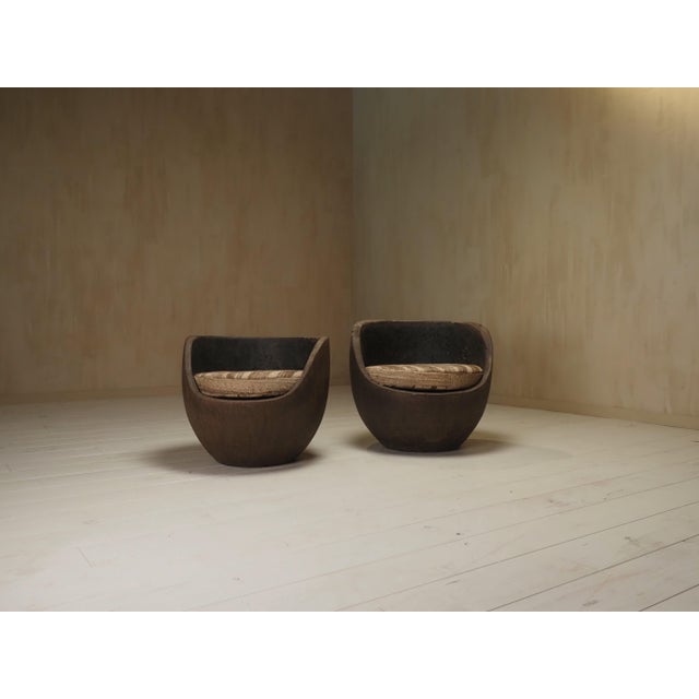 A pair of mid century lounge chairs, handcrafted from solid palm wood. Their sculptural, organic forms showcase the...