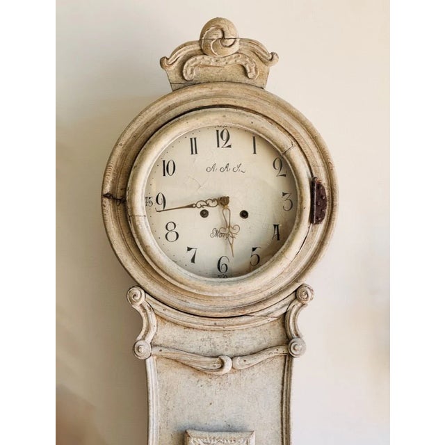 Elegant Swedish Fryksdahl grandfather clock with a raised base, c. 1820, Mora Clock off-white/cream painted. Having enamel...