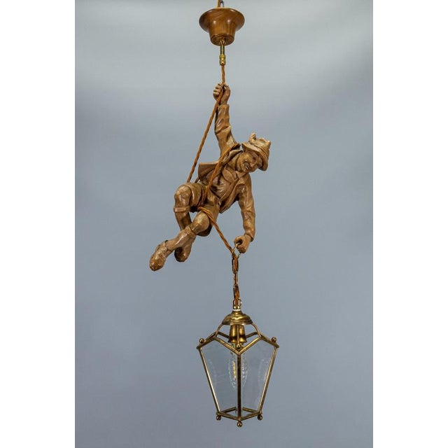 Charming German carved linden wood mountaineer pendant light dating from the 1950s, featuring a finely carved climber...