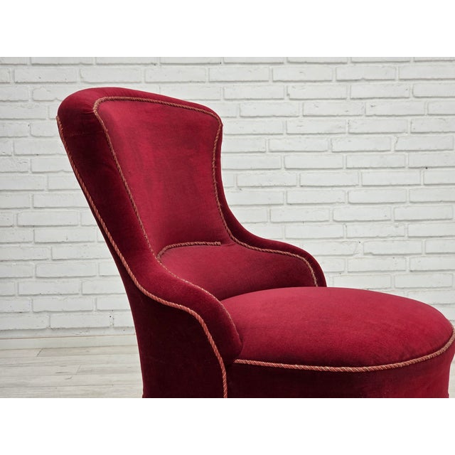 1950s, Danish cocktail loungechair. Cherry-red furniture velour, beech wood legs, brass springs in the seat. Chair was...