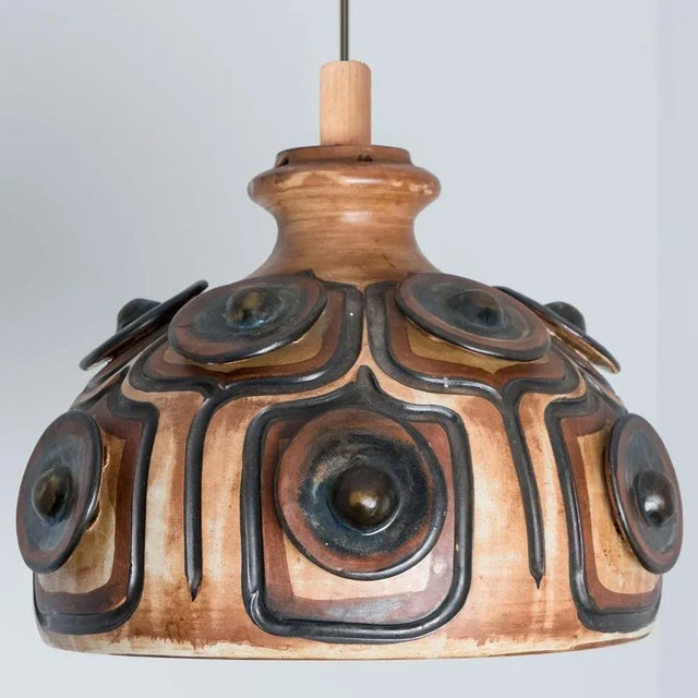 Stunning round hanging lamp with an unusual shape, made with rich brown colored black and beige ceramics, manufactured in...