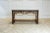 The Tommy Bahama Home Royal Kahala console table has a Chinese Chippendale design and a Black Penn shell top with a...