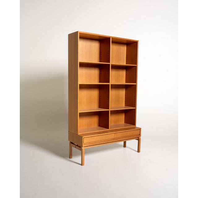 Oak bookcase with a large open structure, adjustable shelves, and two lower drawers. Designed by marian grabinski, sweden,...